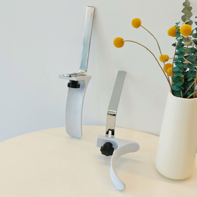 Gli accessori ginecologici del letto di ospedale inquadrano il materiale bianco dell'ABS