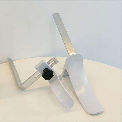 Gli accessori ginecologici del letto di ospedale inquadrano il materiale bianco dell'ABS