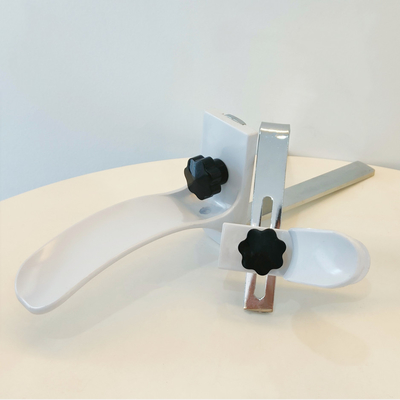 Gli accessori ginecologici del letto di ospedale inquadrano il materiale bianco dell'ABS